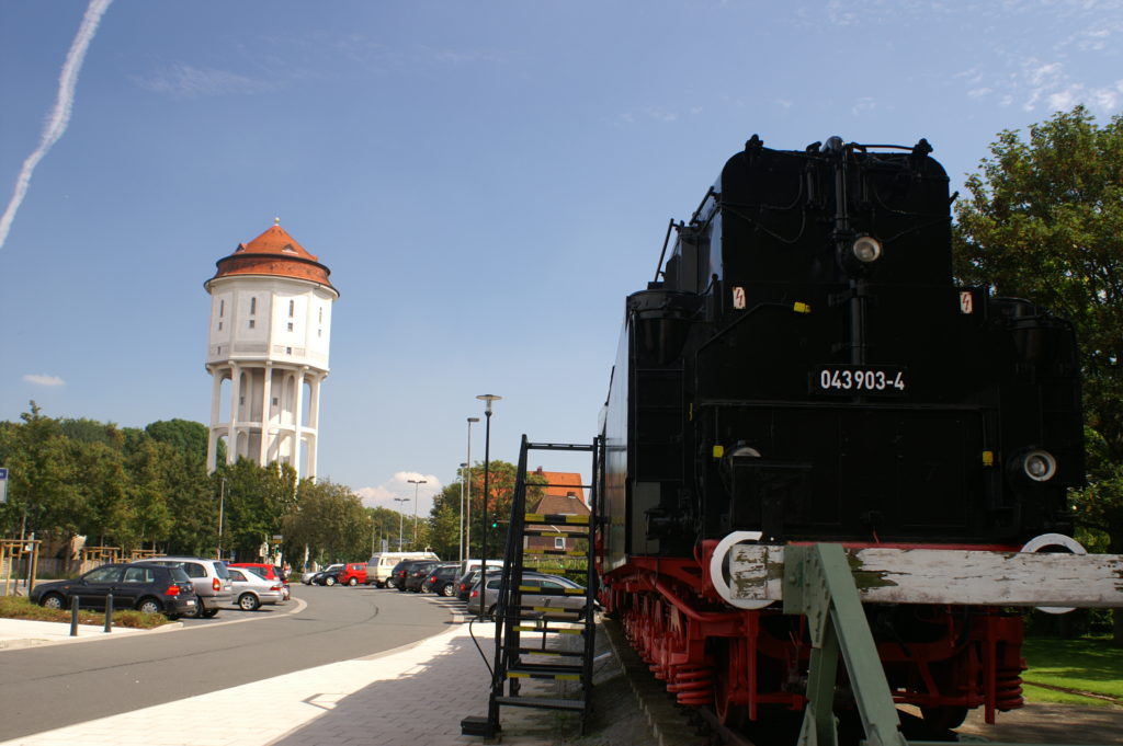 Water tower and old steam train next to Emden's central station
